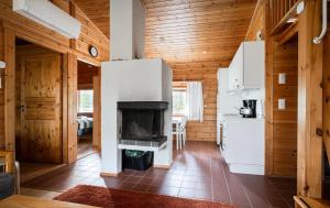 a kitchen with a fireplace in a wooden house at Mökki Vierumäki in Myllykylä