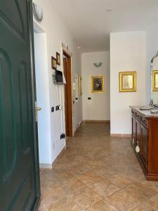 a hallway with a green door and a kitchen at Domu Bella in Decimomannu