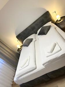 a bedroom with a white bed with two pillows at Ferienwohnung am Wildpark Eichert HDH in Heidenheim an der Brenz