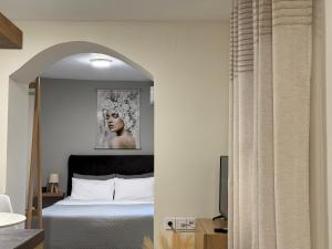 a bedroom with a bed and a picture of a woman at The Central Retreat 2 in Mytilene +13 photos