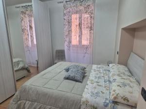 a bedroom with a bed and two windows at Dimora del Funaro con parcheggio in Orvieto