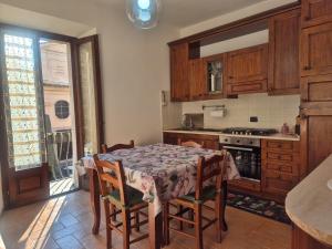 a kitchen with a table with chairs and a table and a table and a kitchen at Dimora del Funaro con parcheggio in Orvieto