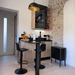 a kitchen with a table and stools in a room at Mougins Centre - Bastide pierre rénovée spa et piscine privé in Mougins