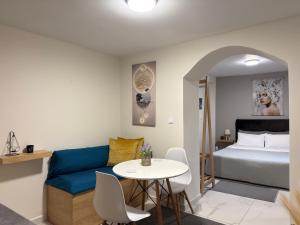 a room with a bed and a blue couch and a table at The Central Retreat 2 in Mytilene