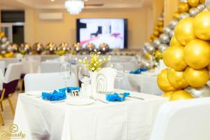 eine Gruppe von Tischen mit weißen Stühlen und goldenen Luftballons in der Unterkunft Zimansky Hotel in Accra + 35 Fotos