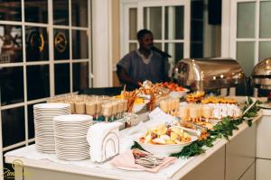 ein Tisch mit Tellern und Schüsseln voller Essen in der Unterkunft Zimansky Hotel in Accra