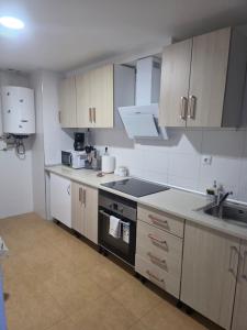 a kitchen with a sink and a stove top oven at Casa de sney in Sarria