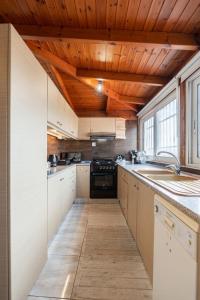a kitchen with white cabinets and a wooden ceiling at Zafeiris House in Kalívia Thorikoú