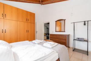 a bedroom with a large white bed and wooden cabinets at Zafeiris House in Kalívia Thorikoú +45 photos