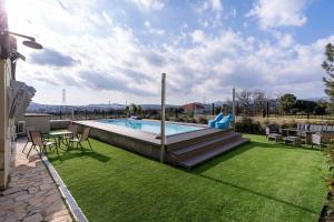 a backyard with a swimming pool and green grass at Zafeiris House in Kalívia Thorikoú