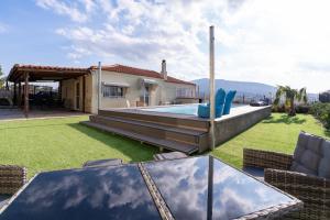 a backyard with a pool and a house at Zafeiris House in Kalívia Thorikoú