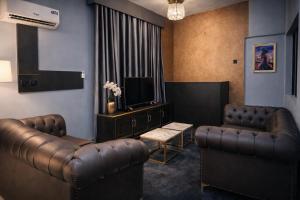 a waiting room with leather furniture and a flat screen tv at Luxury 6 bedroom villa in independence layout 247 power parking and Wifi in Enugu +3 photos
