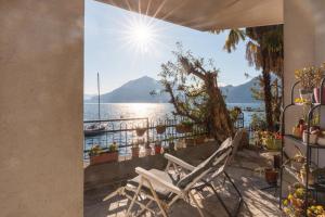 a white chair sitting on a balcony overlooking the water at Gli Oleandri in Bellano