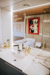 a bathroom with a white sink and a mirror at The living gallery in Roja