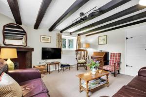 a living room with a couch and a tv at Cascade Cottage Exford in Exford