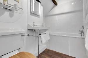 a white bathroom with a sink and a tub at Cascade Cottage Exford in Exford +25 photos