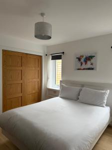 a bedroom with a white bed and a wooden door at Gili Taigh in Fort William