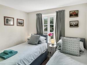 a bedroom with two beds and a window at Grace Cottage Porlock in Porlock