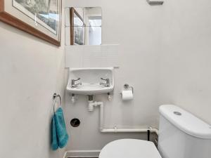 a white bathroom with a toilet and a sink at Grace Cottage Porlock in Porlock +13 photos