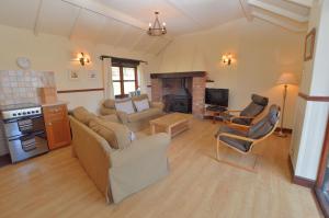 a living room with a couch and a fireplace at The Smithy nr Huntsham in Tiverton