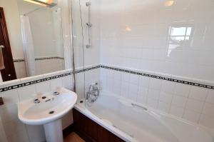 a white bathroom with a sink and a bath tub at The Smithy nr Huntsham in Tiverton +14 photos