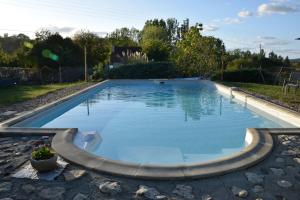 a large pool with blue water in a yard at La Tulipe Périgourdine in Le Buisson de Cadouin
