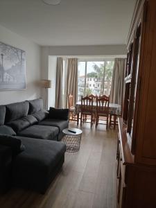 a living room with a couch and a table and chairs at Blue Ocean Apartments in Benalmádena