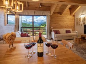 a bottle of wine sitting on a table with wine glasses at SKYWAY LOFT - Residence Veronza con piscina, Dolomiti Affitti in Cavalese