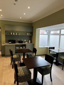 a dining room with tables and chairs and a kitchen at Hamilton House, Chester in Hope