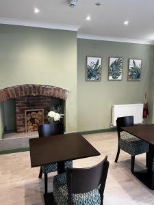 a waiting room with two tables and a fireplace at Hamilton House, Chester in Hope
