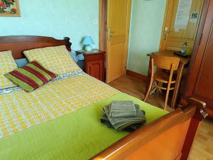 a bedroom with a bed with a green comforter at Chambres d'hôtes Chez nous in Nantheuil +4 photos