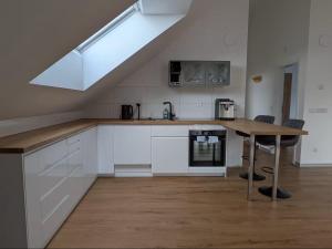 a kitchen with white cabinets and a wooden table at LechApartments in Kaufering +7 photos