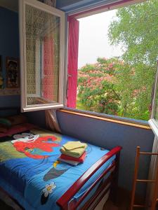 a bed in a room with a window at Chambres d'hôtes Chez nous in Nantheuil