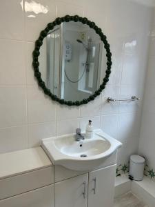 a white bathroom with a sink and a mirror at Stylish 2-Bed Apartment with Parking in CBG
