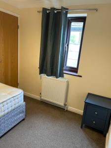 a bedroom with a bed and a window and a table at Stylish 2-Bed Apartment with Parking in CBG