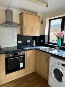 a kitchen with a sink and a dishwasher at Stylish 2-Bed Apartment with Parking in CBG
