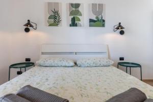 a bedroom with a bed with two chairs and two paintings on the wall at Gli Oleandri in Bellano