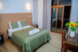 a hotel room with a bed and a vase of flowers at HOTEL TERRANOVA Abancay in Abancay
