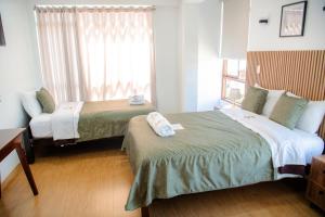 a hotel room with two beds and a window at HOTEL TERRANOVA Abancay in Abancay