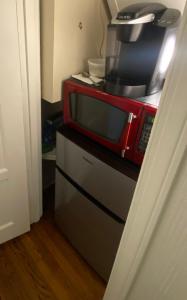 a red microwave sitting on top of a refrigerator at 2 Born Wealthy in 1926 in Elkins Park