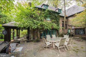 a patio with a table and chairs in front of a house at 2 Born Wealthy in 1926 in Elkins Park