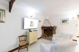 a living room with a white couch and a fireplace at Room with kitchen & free parking 100 m from the sea in Quartu Sant'Elena