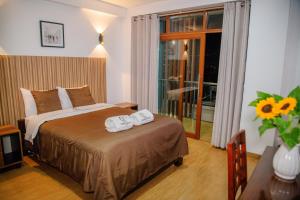 a bedroom with a bed with two towels on it at HOTEL TERRANOVA Abancay in Abancay