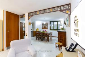 a living room with a white couch and a table at Room with kitchen & free parking 100 m from the sea in Quartu Sant'Elena