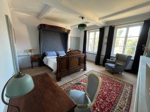 a bedroom with a bed and a table and chairs at Maison de caractère au calme en pleine campagne in Rollancourt