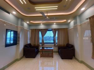 a living room with two chairs and a table at Hotel Raj in mayapur