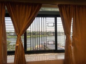 a window with curtains and a view of a river at Hotel Raj in mayapur