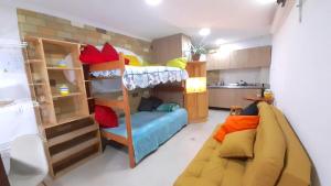 a small room with a bunk bed and a couch at Hostal SAVEVA in Medellín