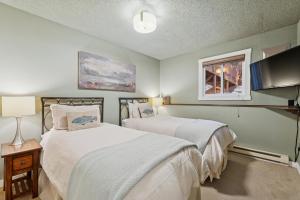 a bedroom with two beds and a flat screen tv at Moose Tracks in Whitefish