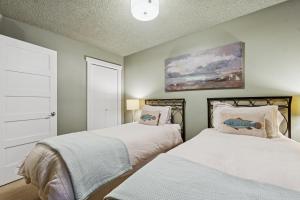 a bedroom with two beds and a painting on the wall at Moose Tracks in Whitefish